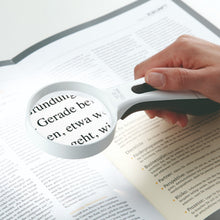 ERGO Lux magnifier with LED light on reading magnified image of book