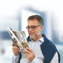 mature man wearing improvision spectacles reading magazine